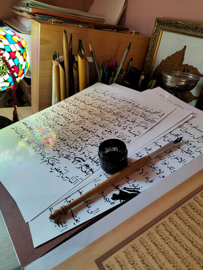 Documentary study of Ottoman-era Naskh script and the physical constraints of the scribe's workshop. This photograph captures the materiality of manuscript production, showing the interplay between soot-based ink, hand-cut reed pens (qalams), and the metic